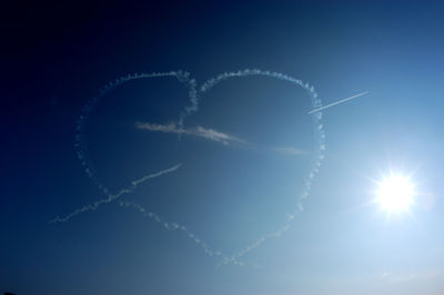 Low angle view of heart shape against blue sky