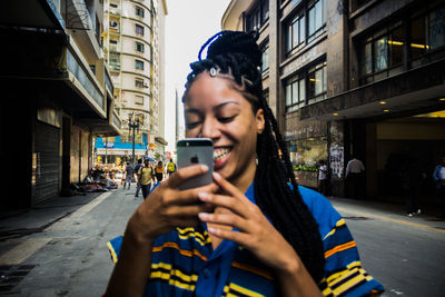 Young man using smart phone on street