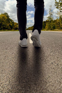 Low section of man standing on road