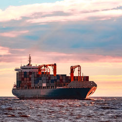 Ship in sea against sky during sunset