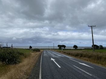 Road amidst field against sky