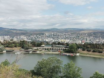 Scenic view of river by city against sky