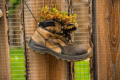 Close-up of shoes on metal fence
