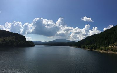 Scenic view of lake by trees against sky