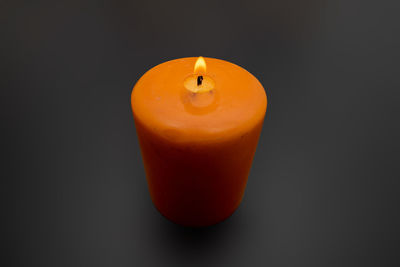 Close-up of orange candle against black background