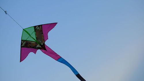 Low angle view of flag against clear blue sky