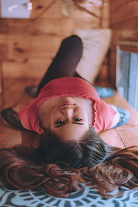 Portrait of woman lying on bed at home