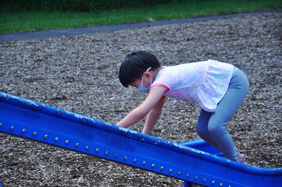 Side view of girl playing on slide