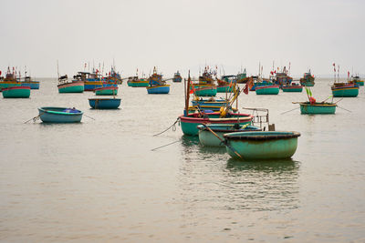 Boats in sea against clear sky