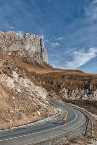 Scenic view of road by mountain against sky