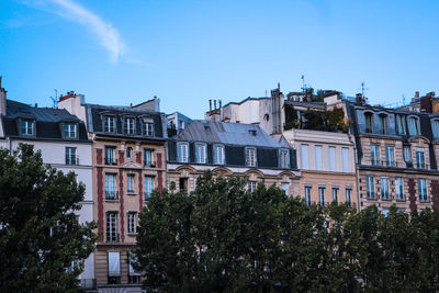 Fornt view of historical buildings in city against blue sky