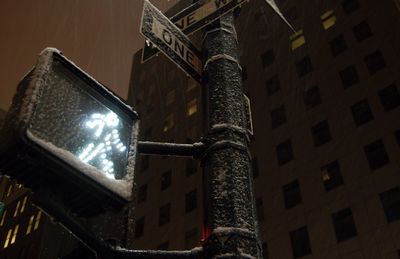 Low angle view of illuminated street light against building at night