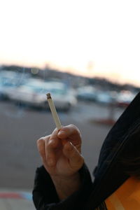 Close-up of hand holding cigarette