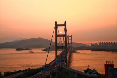 Tsing ma bridge over sea against clear sky during sunset