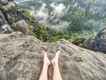 Couple resting on the top of the mountain after climbing. deep valley below