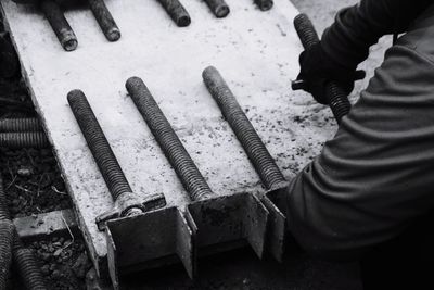 High angle view of man adjusting metal