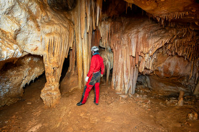 Rear view of man standing in cave