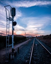 Railroad tracks by signal against sky