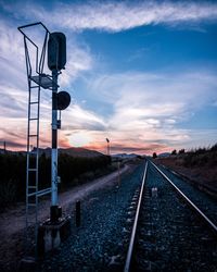 Railroad tracks by road against sky