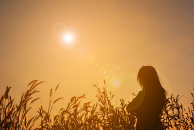 Silhouette person standing against sky during sunset