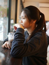 Asian girl sit and drink cold cocoa