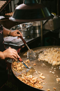 Cropped hand of person preparing food in kitchen