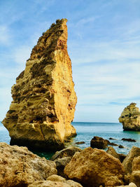 Rocks on sea shore against sky