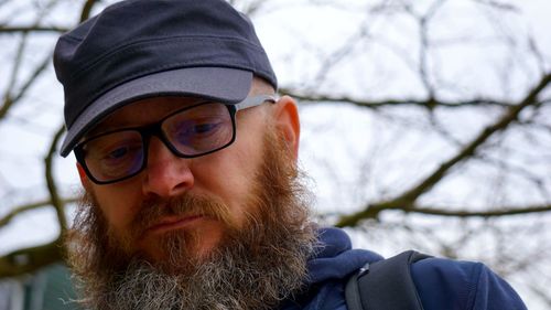 Close-up of bearded man wearing cap and eyeglasses