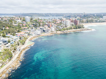 High angle view of buildings by sea against sky