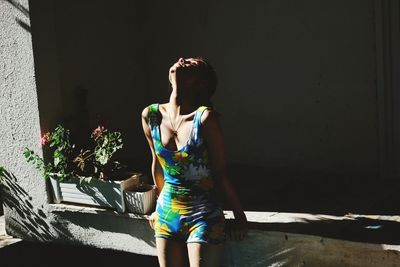 Young woman standing against wall
