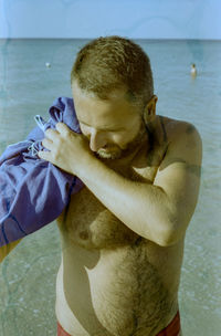 Full length of man holding surfboard at beach