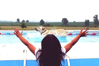 Rear view of woman in swimming pool against clear sky