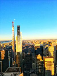 Modern buildings in city against clear blue sky