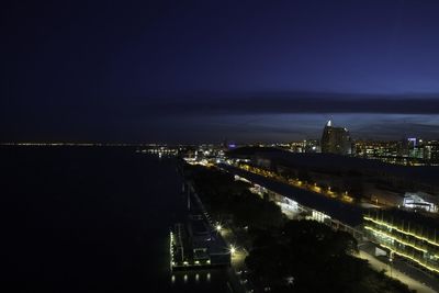 Illuminated cityscape against sky at night