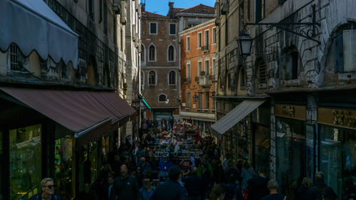 People on street amidst buildings in city