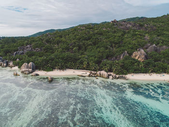 Scenic view of sea by mountains against sky