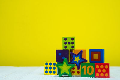 Close-up of toys on table against yellow background