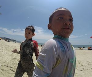 Portrait of boy on beach against sky