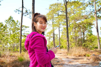 Portrait of girl standing by tree