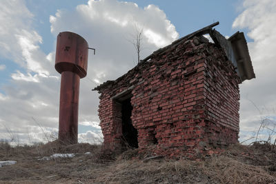 Low angle view of old building on field against sky