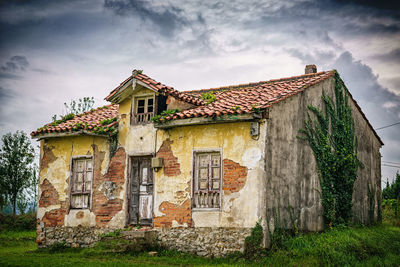 Low angle view of abandoned house against sky