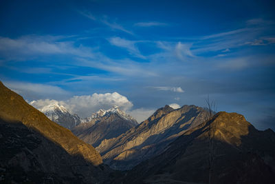 Scenic view of snowcapped mountains against blue sky