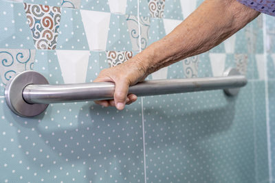 Cropped hand of senior woman holding handrail