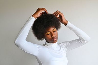 Portrait of young woman against wall