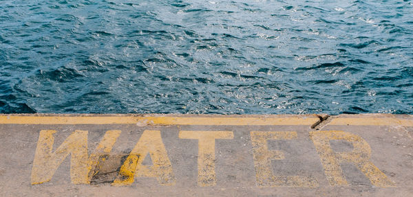 High angle view of text on pier in sea