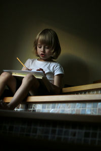 Full length of a boy sitting on paper