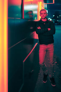 Full length portrait of young man standing at night