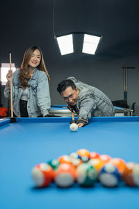 Midsection of woman playing pool