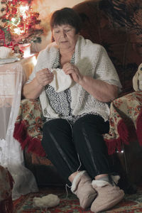 Full length of woman sitting on sofa