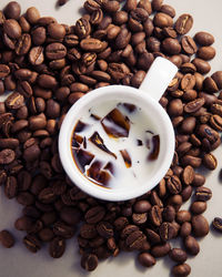 Directly above shot of coffee amidst beans on table